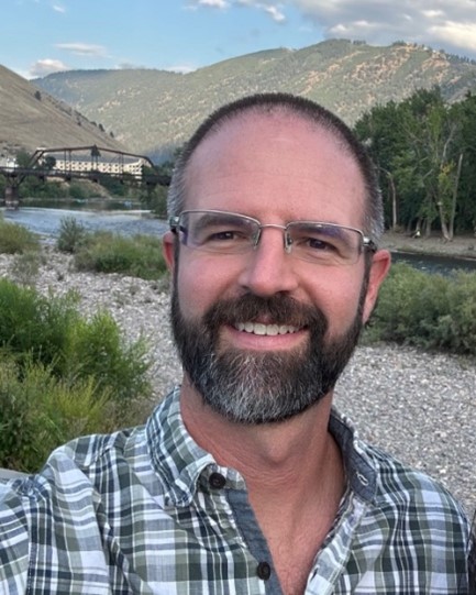 A man with a mountain behind him.